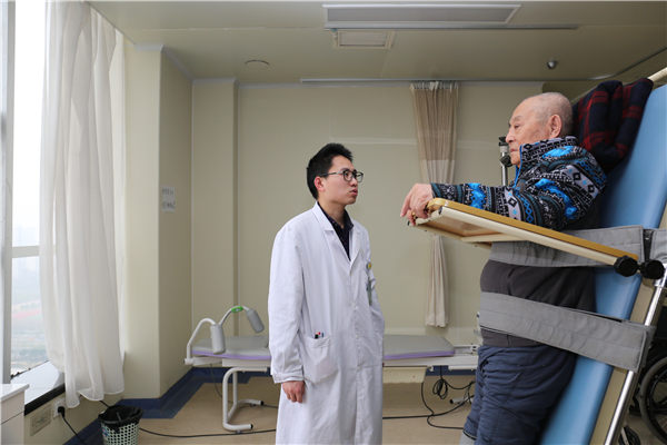 Cheng Chi, a male nurse talks to a patient. (Photo/China Daily)