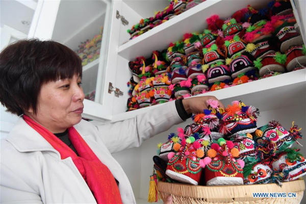 Collector Hu Shuqing displays her collection of tiger-head shoes in Zhengzhou City of central China's Henan Province, March 10, 2017. (Xinhua/Zhu Xiang) 