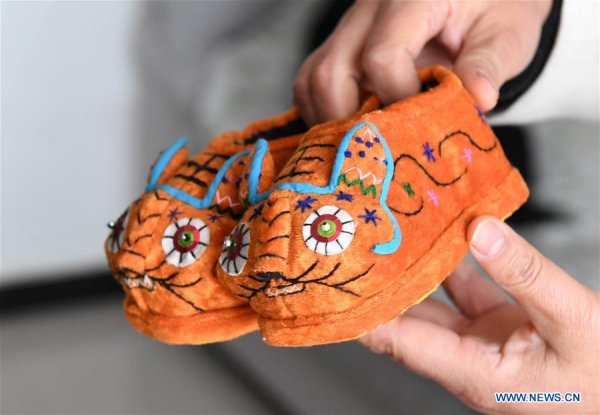 Collector Hu Shuqing displays her collection of tiger-head shoes in Zhengzhou City of central China's Henan Province, March 10, 2017. (Xinhua/Zhu Xiang) 