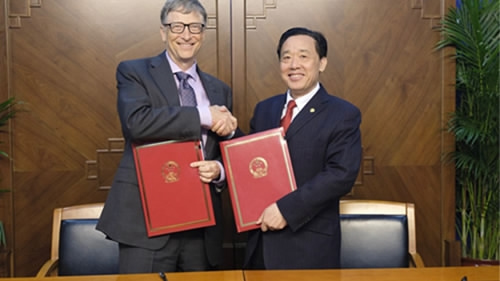 Bill Gates shakes hands with a Chinese official after signing a contact. (Photo/CGTN)