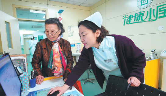 A nurse takes the health details of a senior patient at Donghuashi Community Health Center in Beijing. (Luo Xiaoguang / Xinhua)