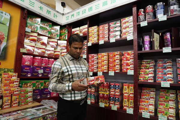 Anura Banda, CEO of Beijing Heavenly Trade Co Ltd, examines tea at his tea shop in Beijing, China, on April 19, 2017. (Photo by Li Xiupeng / chinadaily.com.cn)