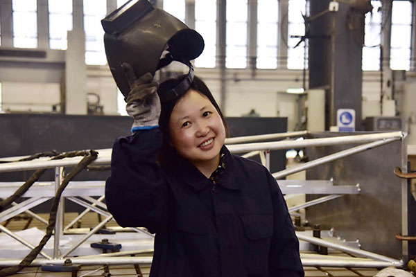 Huang Chunyan takes off her welding helmet at the workshop of Anhui Brainware Chang'an Electronics Co Ltd in Lu'an, Anhui province, April 25, 2017. (Photo by Song Wei/chinadaily.com.cn)