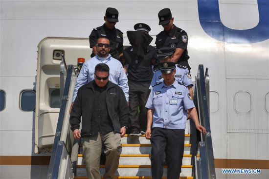 A criminal suspect disembarks under police escort from a plane at Beijing Capital International Airport, in Beijing, China, June 1, 2017. The United States law enforcement handed over a criminal suspect to Chinese police Thursday. (Xinhua/Cai Yang)