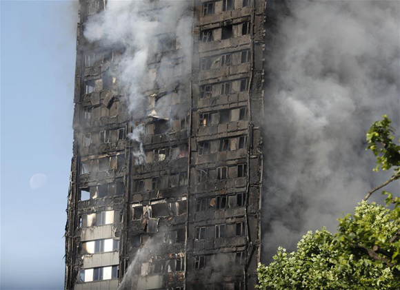 An apartment building is engulfed by a massive fire in western London, Britain, June 14, 2017. A massive fire engulfed a 27-story apartment building in west London early Wednesday as around 30 people have been taken to hospitals following the blaze. (Xinhua/Han Yan)