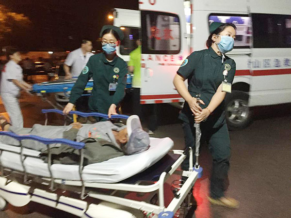 Medical workers transfer an injured man to hospital after an explosion at the gate of a kindergarten in Fengxian county, Jiangsu province on June 15, 2017. At least seven people were killed and 66 others injured. (Photo/Xinhua)