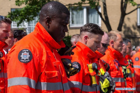 Representatives of the London Fire Brigade and emergency services observe a minute silence outside Notting Hill Methodist Church for the victims of the Grenfell Tower Fire in London, Britain on June 19, 2017. Police said Monday the number of dead or missing in the London Grenfell Tower fire has increased to 79. (Xinhua/Ray Tang)