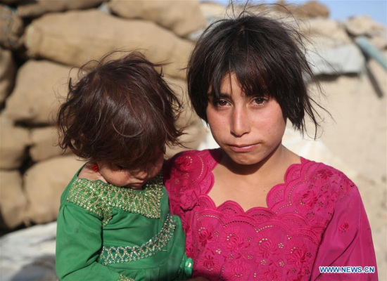 An Afghan displaced child holds her baby sister in Kabul, Afghanistan, June 20, 2017, the World Refugee Day. (Xinhua/Rahmat Alizadah)