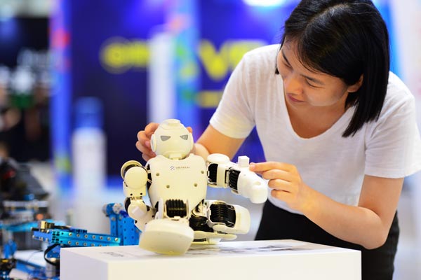 A visitor plays with an exhibit at the forum. Wei Peiquan / Xinhua