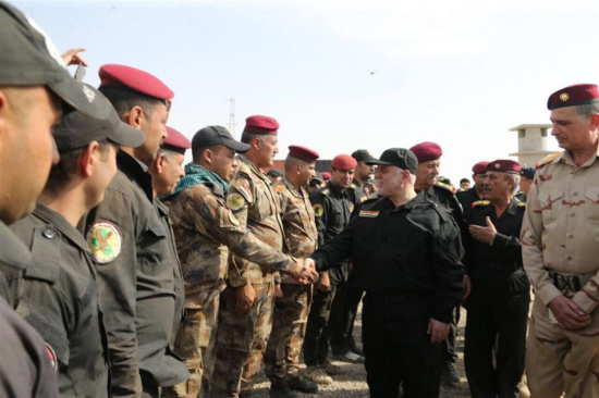 Iraqi Prime Minister Haider al-Abadi shakes hands with army officers in Mosul, Iraq, on July 9, 2017. Mosul came under IS control in June 2014. (Xinhua/Office of Iraqi Prime Minister)