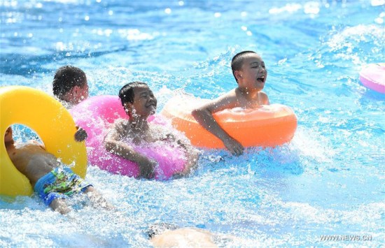 Kids played in water to keep cool in a water park in Chongqing, July 11, 2017. An orange level high temperature warning is issued by the meteorological observatory of southwest China's Chongqing Municipality on Tuesday. (Xinhua/Wang Quanchao)