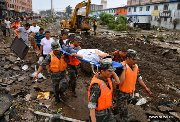 Rescuers transfer an injured person in Yongji County, northeast China's Jilin Province, July 14, 2017. Heavy rain caused waterlogging in Yongji County from July 13 to 14. (Xinhua/Xu Chang)