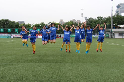 Girls from the soccer team of Yangliujing Township Middle School in Southwest China's Yunnan Province hop for a picture after finishing half a day's training with foreign coaches in Beijing (Photo: Li Ruohan/GT)