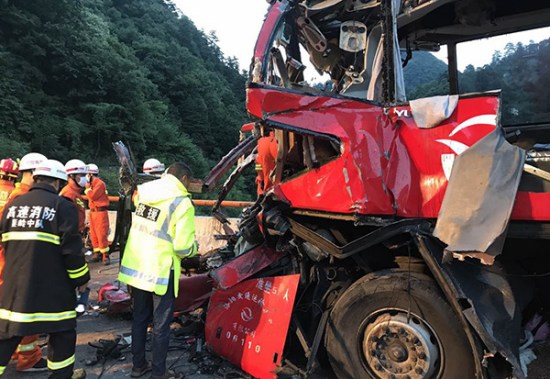 Rescuers check the wreckage on Friday of the bus that crashed at the mouth of a tunnel on the Beijing-Kunming Expressway. (Photo/Xinhua)