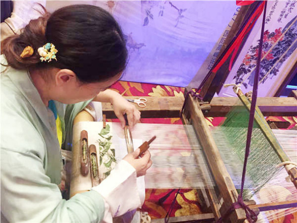 A Chinese artist shows the traditional making technique of Kesi, a type of silk tapestry woven with intricate pictures. (Photo by Bi Nan/chinadaily.com.cn)