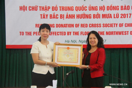 Yin Haihong (L), Charge D'affaires of the Chinese Embassy to Vietnam, receives a certificate of award on behalf of the Red Cross Society of China from Nguyen Thi Xuan Thu, President of Vietnam Red Cross Society, in Hanoi, Vietnam, Aug. 23, 2017. (Xinhua/Le Yanna)