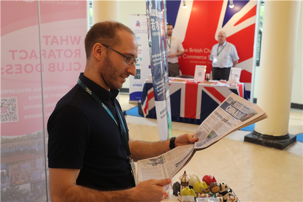 A visitor reads a copy of China Daily at the event. (Photo:chinadaily.com.cn/Gao Erqiang)