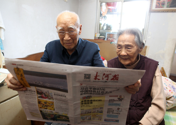 Zhao Jiujing, 96, and Meng Shulan, 99 read Dahe Daily, the local newspaper. (Photo by Xu Junwen/chinadaily.com.cn)