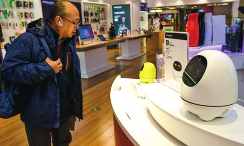 A customer interacts with a household robot in a high-tech product store. (Photo: Li Hao/GT)