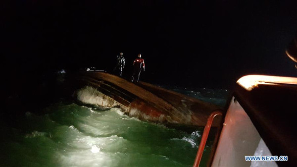 South Korean coast guards reach the cpasized fishing boat near South Korea's western waters, Jan. 21, 2018. Three people were found dead as a suspected Chinese fishing boat capsized near South Korea's western waters, Yonhap news agency reported on Sunday. (Xinhua)