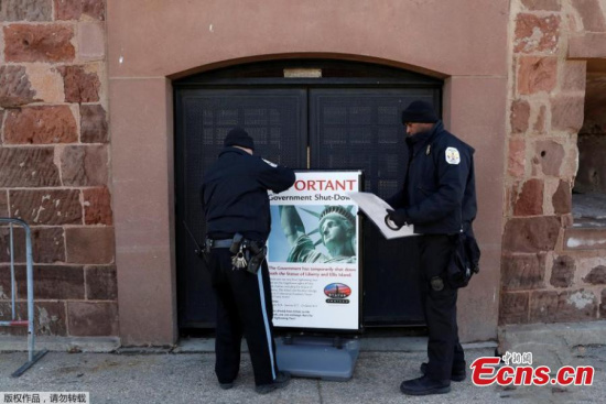 Members of the U.S. Park Police place signage near the ferry dock for the Statue of Liberty announcing its closure following a U.S. government shutdown in Manhattan, New York, U.S., Jan. 20, 2018. (Photo/Agencies)