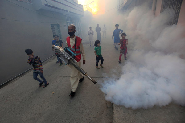 A man fumigates a street as an anti-dengue fever measure in Pakistan. (Photo by FAISAL MAHMOOD/FOR CHINA DAILY)