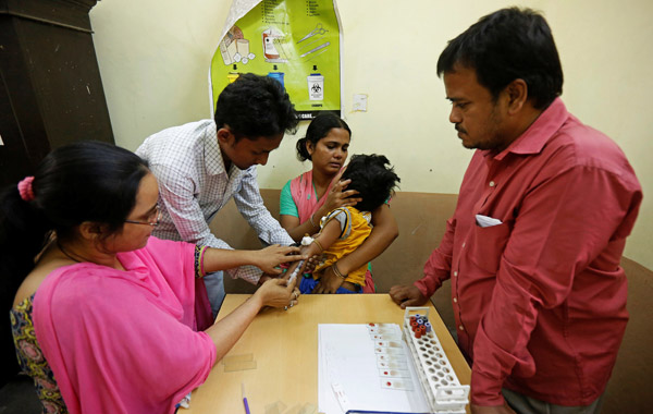 A health worker collects a blood sample from a patient at a dengue fever center in India in November. (Photo by RUPAK DE CHOWDHURI/FOR CHINA DAILY)