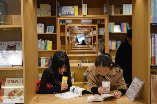 Two customers flip through books at the Light Space Xinhua Bookstore in Shanghai on Monday. (Photo: Qi Xijia/GT)