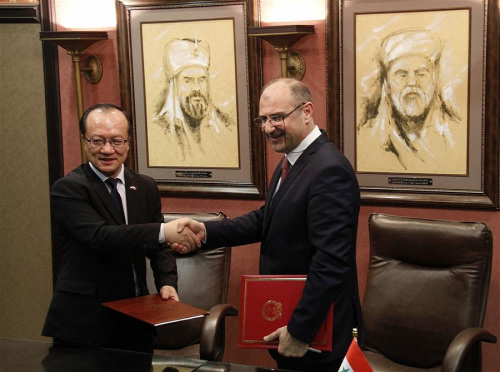 China's Ambassador to Syria Qi Qianjin (L) shakes hands with the head of Assad University Hospital Jaber Ibrahim during the delivery ceremony held in Damascus, Syria, March 7, 2018. (Xinhua/Hummam Sheikh Ali)