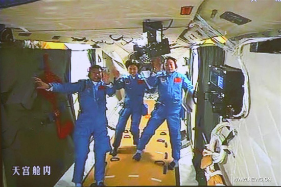 Photo taken on June 18, 2012 shows the screen at the Beijing Aerospace Control Center showing Chinese astronauts Jing Haipeng, Liu Wang and Liu Yang at the orbiting Tiangong-1 space lab module. (Xinhua/Zha Chunming)