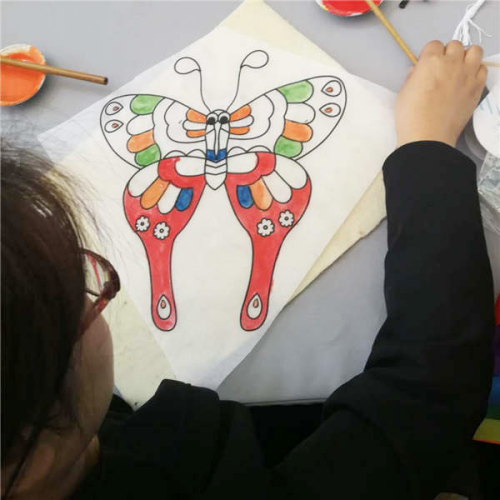 A visitor experiences the making of handmade kite during the show. (Photo provided to chinadaily.com.cn)