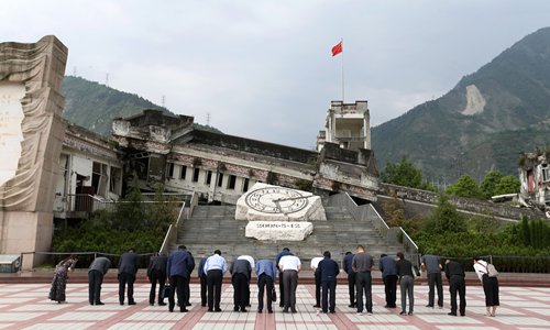 Visitors bow in front of the Xuankou Middle School Memorial in Wenchuan county. (Photo: Cui Meng/GT)