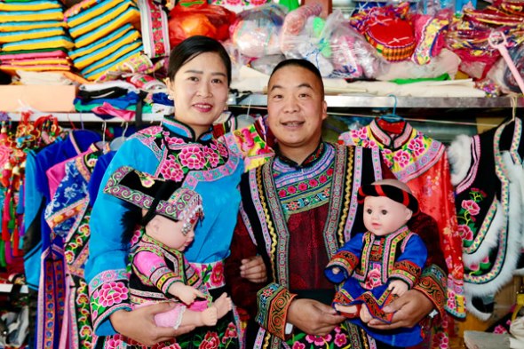 Chen and his wife pose for a photo at their shop in Yanmen. (Photo by Duan Jinzhe/provided to chinadaily.com.cn)