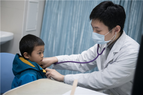 Pediatrician Yang Yang checks a child at Guangzhou Women and Children's Medical Center in Guangdong province in January. (PhotoZHANG ZIWANG/FOR CHINA DAILY)