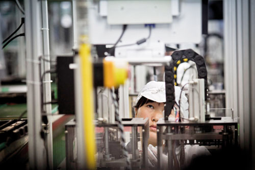 An employee of Hon Hai Precision Industry Co Ltd, which uses the trade name Foxconn, works on a production line in the Longhua Science and Technology Park in Shenzhen. Terry Gou, chairman of Foxconn T