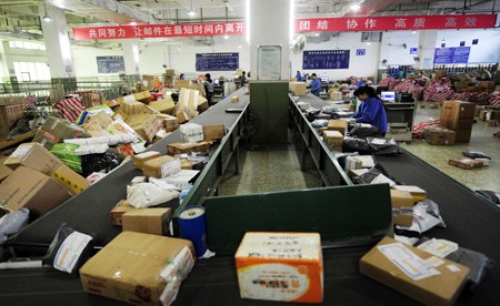 Workers categorizing packages in a post office in Chongqing before the Spring Festival holiday, which started on Jan 22. [Photo / China Daily]