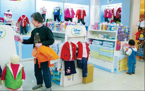 Shopping for children's wear at a store in Qingdao, Shandong province. Many little-known companies together hold more than 95 percent of the Chinese market for baby and child products, while the top 10 brands each have a small share. [Photo / China Daily]