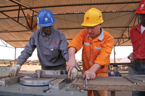 Chinese workers train their Angolan colleagues to roll steel at a CITIC Construction Co Ltd worksite in Luanda, the capital city of Angola. Officials say the development of Chinese construction contractors in Africa will continue in the coming years.[Photo/China Daily]