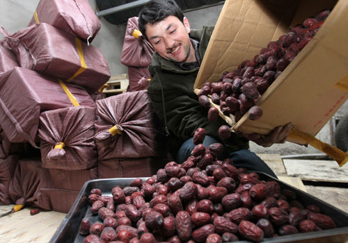 Mehmet unpacks jujubes, which he introduced to a local supermarket, in Changchun, Jilin province, on Sunday. [Photo/China Daily]