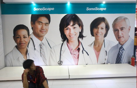 A visitor sits against an advertisement board at an international medical equipment exhibition in Fuzhou, capital of Fujian province, on Nov 3, 2011. The Chinese government has encouraged foreign investors to take part in the reform of the country's hospitals. [Photo / China Daily] 