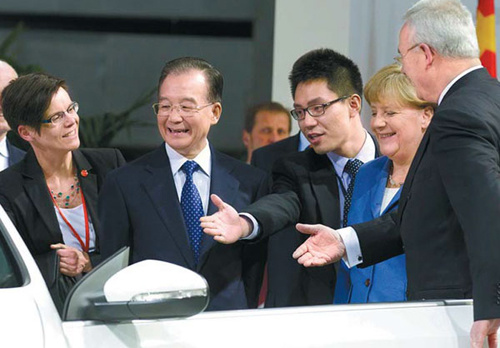 Premier Wen Jiabao and German Chancellor Angela Merkel (second right) are invited to sit in a car during a visit to the Volkswagen headquarters in Wolfsburg, Germany, on Monday. [Markus Schreiber / Associated Press]