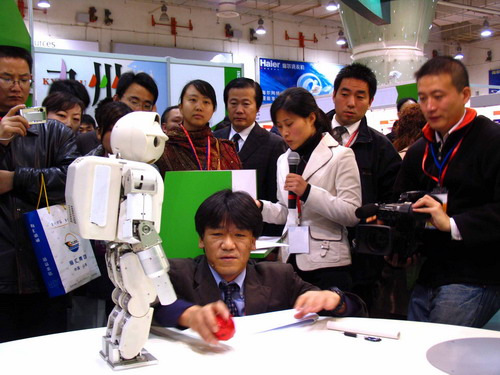 Visitors to a trade fair involving businesses from China, Japan and South Korea look at a robot in Qingdao, Shandong province. Experts say the time is ripe for the three countries to start talks on establishing a free trade area. [Photo/China Daily]