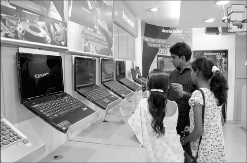 Lenovo-exclusive store owner S. Habeeb (center) showing his customers Lenovo laptop products in his Bangalore store. Two months ago, Lonovo introduced its tablet PC to the Indian market. 