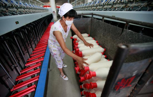 A worker on a textile production line in Huaibei, Anhui province. China's industrial production growth dropped to 9.2 percent year-on-year in July, according to the National Bureau of Statistics. 