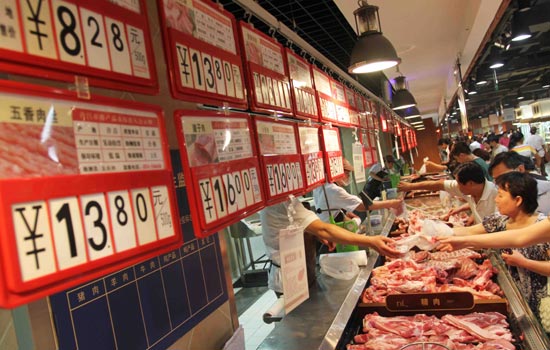 Shoppers buy pork at a market in Xuchang, Henan province. [Photo/China Daily] 