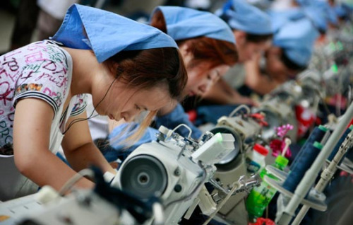 Female workers process products exported to the EU at Wanxiang Garment Factory on July 13, 2012, Huaibei city, Anhui province. [Photo/China Daily] 