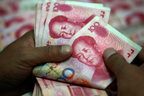 A bank worker counts Chinese 100 yuan banknotes at a bank in Huaibei, East China's Anhui province in this July 6, 2012 file photo. [Xie Zhengyi/Asianewsphoto] 