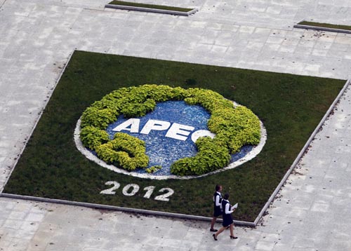 Two volunteers walk outside of the media center for the Asia-Pacific Economic Cooperation forum in Vladivostok on Wednesday. Leaders from Asia-Pacific economies gather in Russia's far east this weekend for talks aimed at promoting trade within the region.