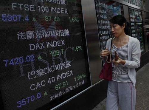 A passerby looks at rising indexes from three major European markets, outside a bank in Hong Kong on Thursday. The US central bank on Thursday said it will launch a fresh round of bond-buying to stimulate the economy, and will purchase $40 billion of mortgage debt each month. [Photo/Agencies]