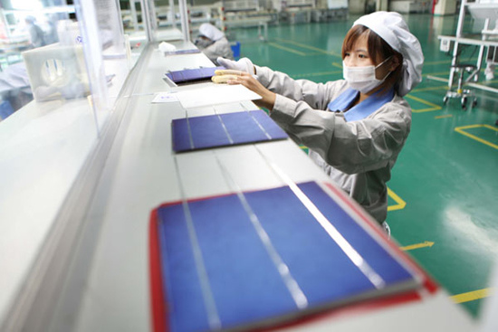 A woman works at a factory producing solar panels for the European market, in Jiangsu province, on Sept 6. The European Commission launched an anti-dumping investigation into made-in-China solar products in early September, forcing some Chinese factories 